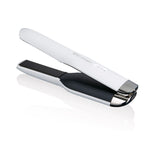 Das ghd Glätteisen Unplugged - Weiß von ghd überzeugt mit kabellosem Design und moderner Optik in Weiß und Schwarz, ideal zum Stylen unterwegs. Auf dem Bild leicht geöffnet vor weißem Hintergrund zu sehen.